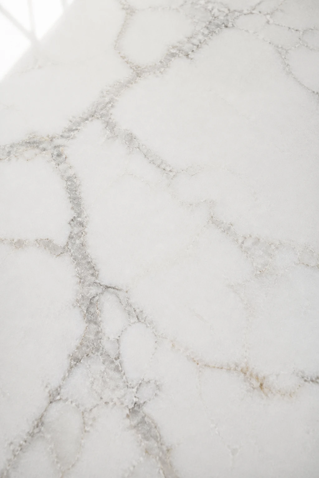 Closeup of polished quartz countertop surface with veining detail